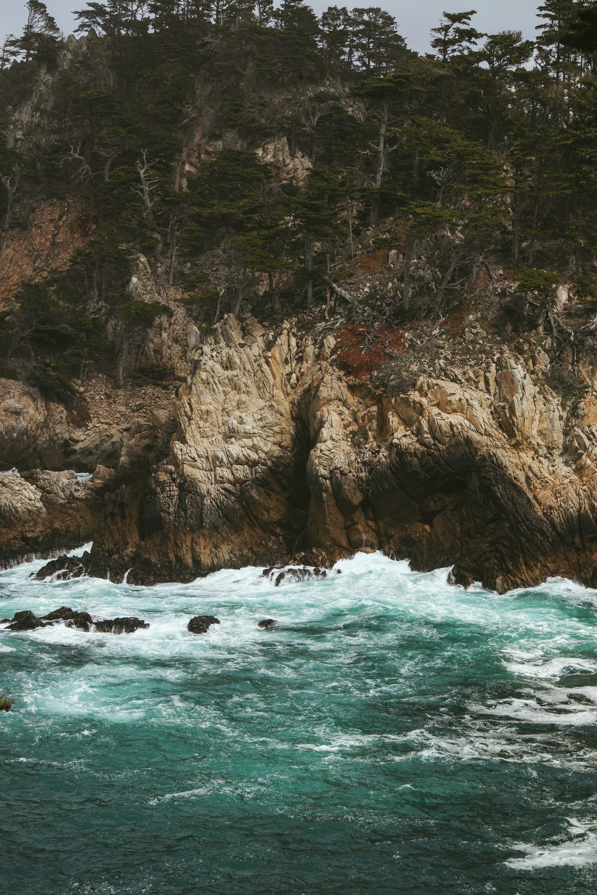 brown rock formation beside body of water during daytime