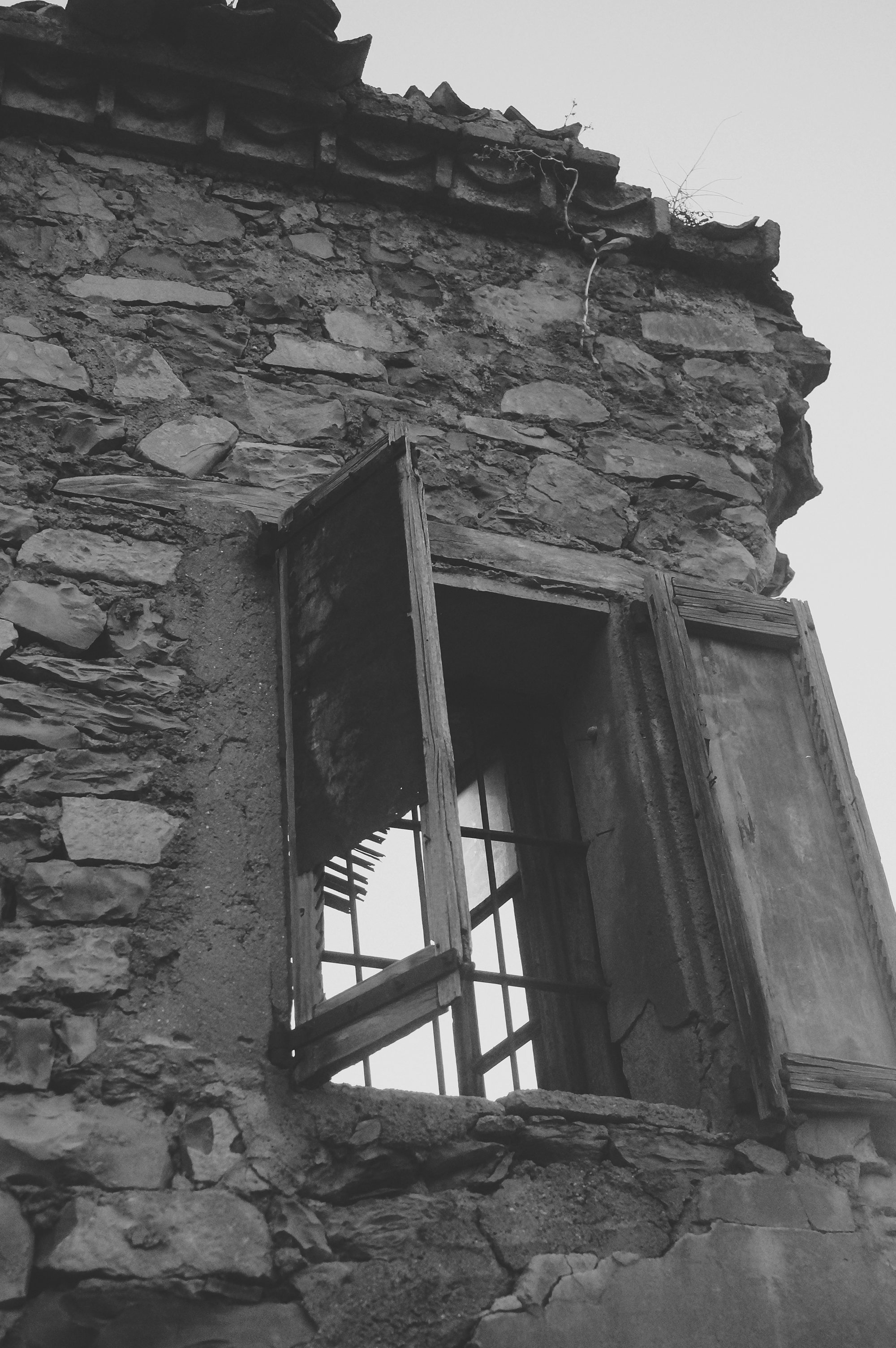 a black and white photo of a window in a stone building