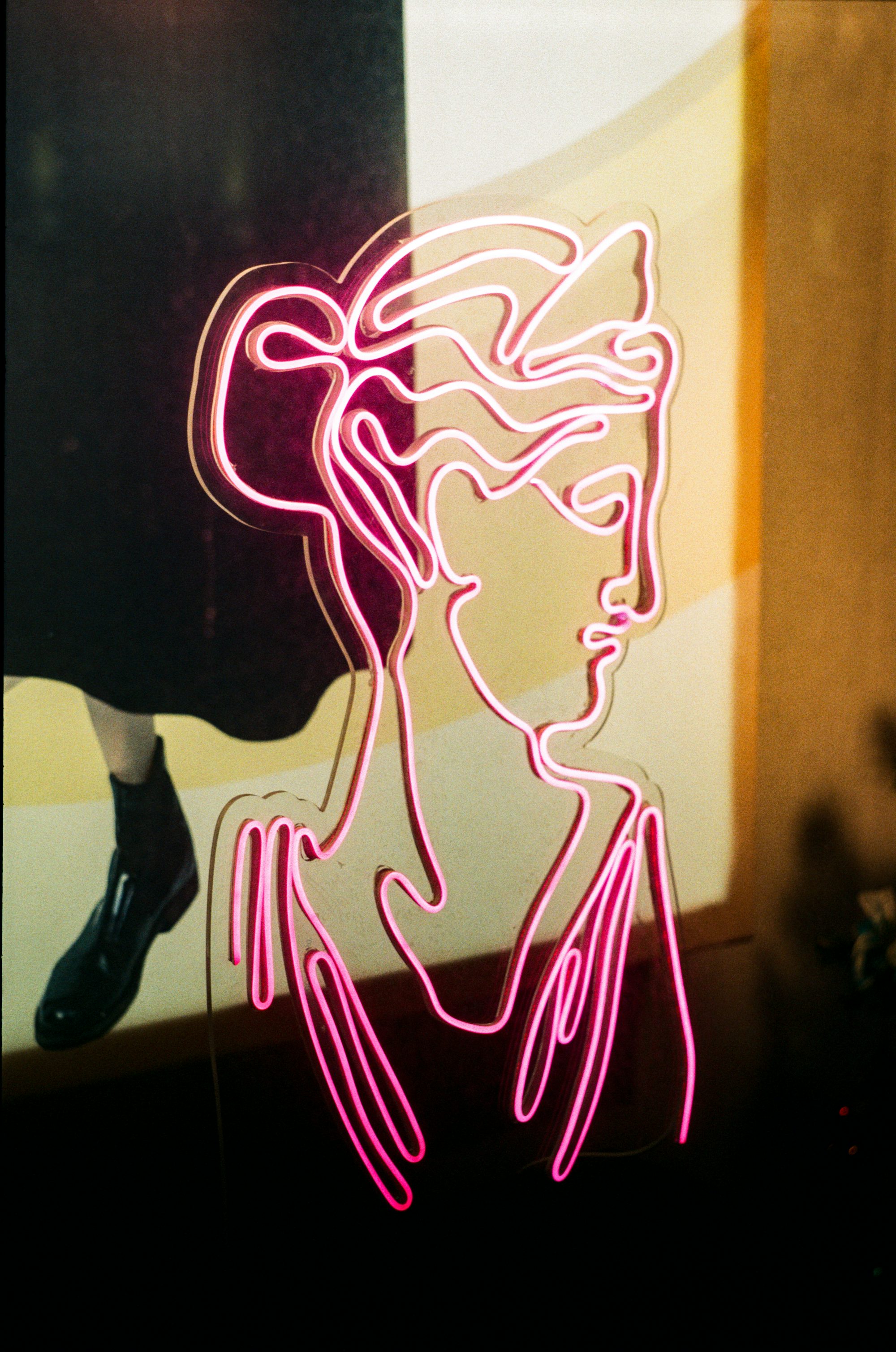 a neon sign with a woman's face on it